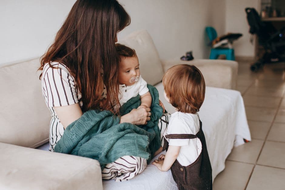 Mother and children share a warm moment on the sofa, filled with love and togetherness.