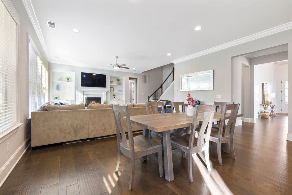 Spacious open plan living and dining area with wooden furniture and natural light.